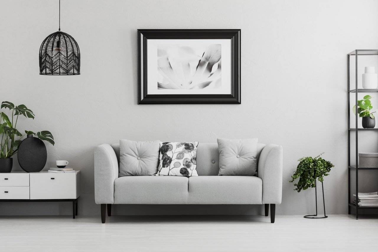 Image of a couple of white sofas standing side of a white wall